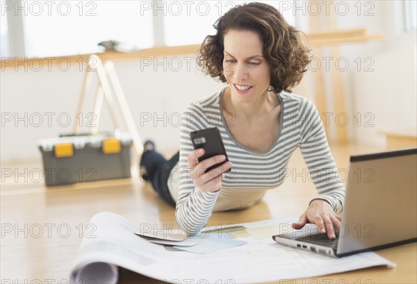 Woman texting and using laptop.