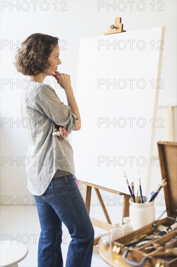 Artist standing in front of canvas.