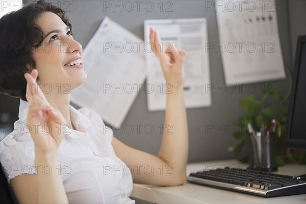 Businesswoman holding fingers crossed.
Photo : Jamie Grill