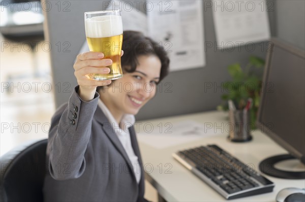 Business woman holding glass of beer.
Photo : Jamie Grill