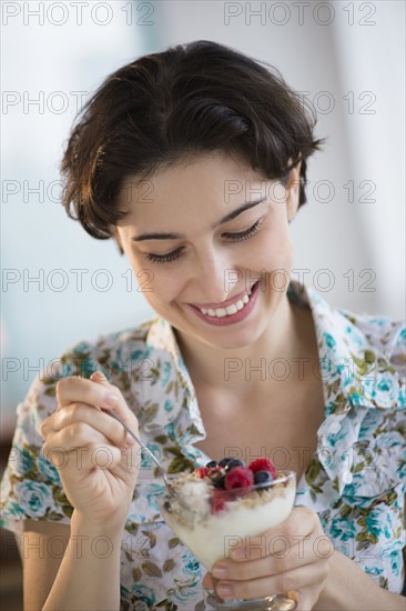 Woman eating yogurt with fruits.
Photo : Jamie Grill