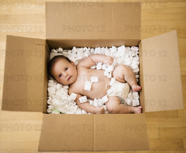 Baby girl (2-5 months) in cardboard box.
Photo : Jamie Grill