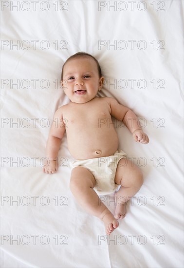 Baby girl (2-5 months) lying on bed.
Photo : Jamie Grill