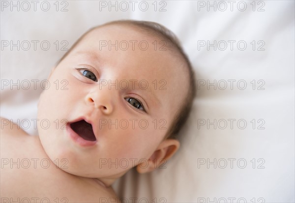 Baby girl (2-5 months) lying on bed.
Photo : Jamie Grill