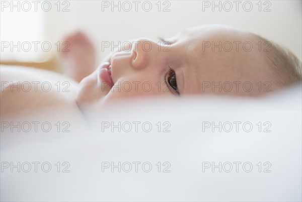 Baby girl (2-5 months) lying on bed.
Photo : Jamie Grill