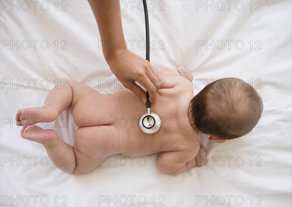 Doctor examining baby girl (2-5 months).
Photo : Jamie Grill