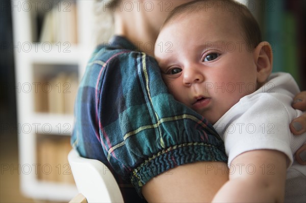 Baby girl (2-5 months) being embraced by mother.
Photo : Jamie Grill