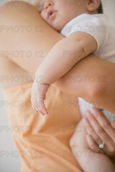 Baby girl (2-5 months) being embraced by mother.
Photo : Jamie Grill