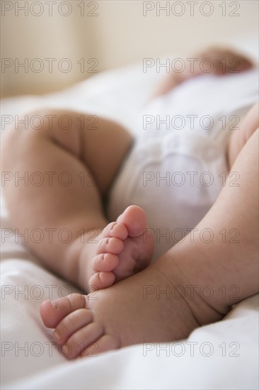 Feet of baby girl (2-5 months) lying in bed.
Photo : Jamie Grill