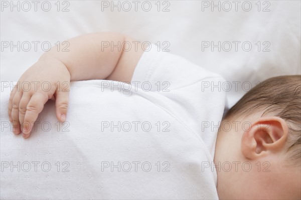 Baby girl (2-5 months) lying in bed.
Photo : Jamie Grill