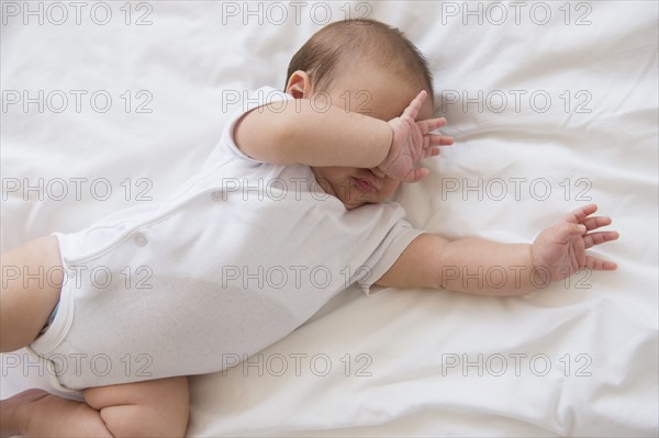 Baby girl (2-5 months) lying on bed and crying.
Photo : Jamie Grill