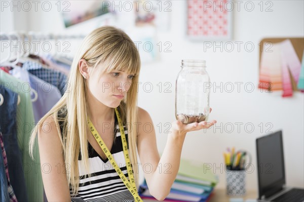 Woman holding empty savings jar.
Photo : Jamie Grill