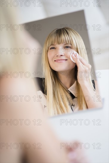 Woman cleansing face with cotton pad.
Photo : Jamie Grill