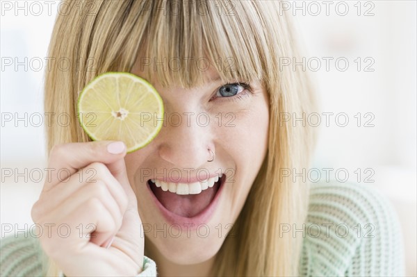 Portrait of woman holding slice of lime.
Photo : Jamie Grill