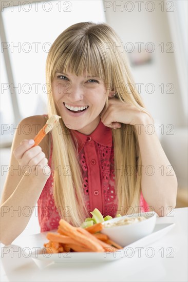 Portrait of woman eating carrots.
Photo : Jamie Grill