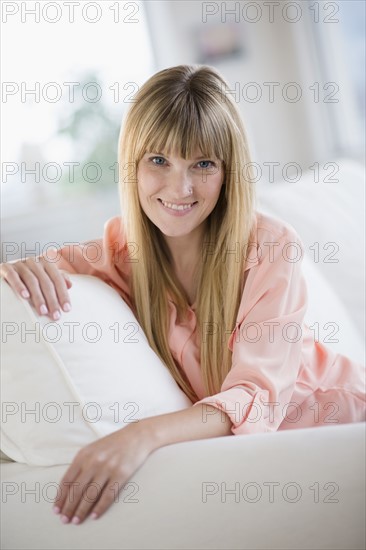 Portrait of woman sitting on sofa.
Photo : Jamie Grill
