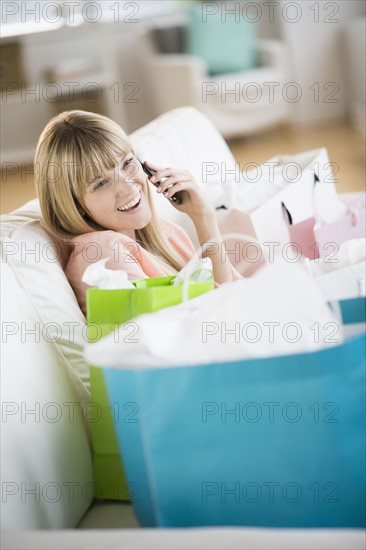 Woman surrounded by shopping bags, talking on phone.
Photo : Jamie Grill