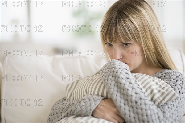 Woman sitting on sofa and thinking.
Photo : Jamie Grill