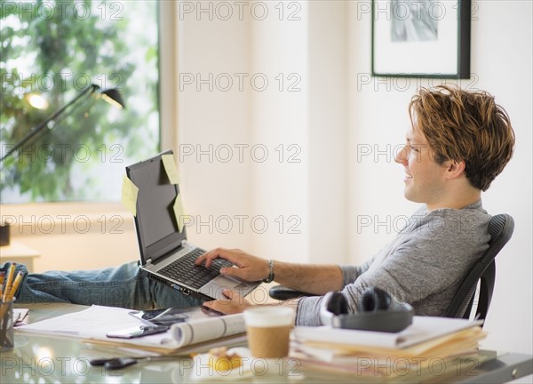 Man using laptop in home office.
Photo : Daniel Grill