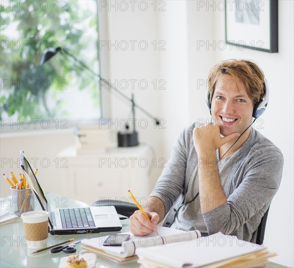 Portrait of man multi-tasking in home office.
Photo : Daniel Grill