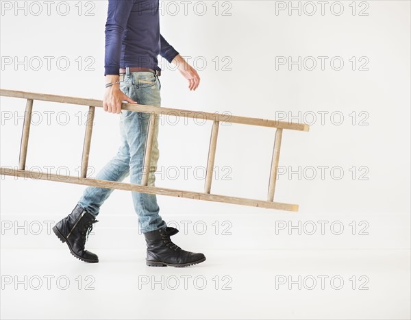 Low section of man carrying ladder.
Photo : Daniel Grill