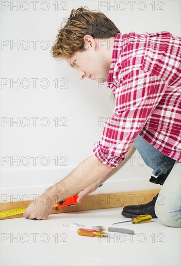 Man measuring baseboard.
Photo : Daniel Grill
