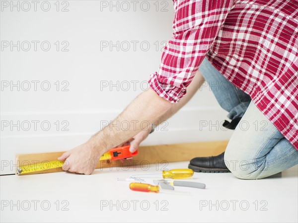 Man measuring baseboard.
Photo : Daniel Grill