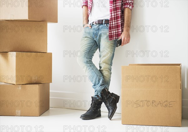 Low section of man next to stack of cardboard boxes.
Photo : Daniel Grill