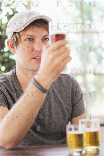 Man looking at glass of beer.
Photo : Daniel Grill