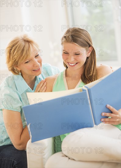 Mother and adult daughter watching photo album.
Photo : Daniel Grill