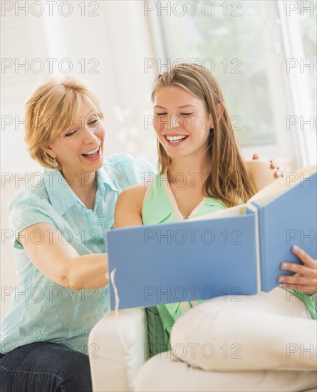 Mother and adult daughter watching photo album.
Photo : Daniel Grill