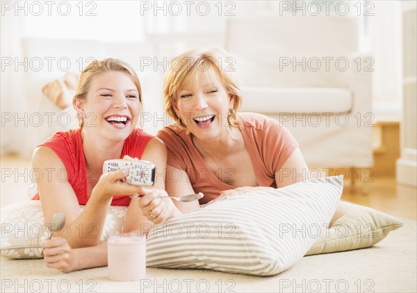 Mother and adult daughter relaxing at home, watching tv.
Photo : Daniel Grill