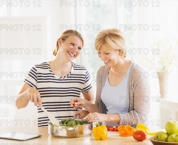 Mother and adult daughter cooking together.
Photo : Daniel Grill