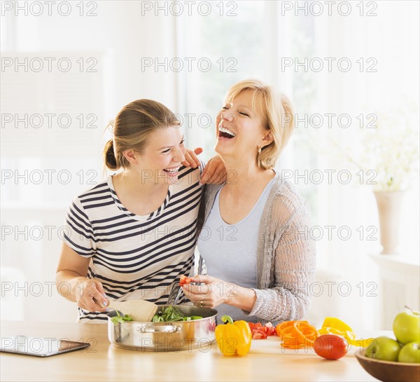 Mother and adult daughter cooking together.
Photo : Daniel Grill