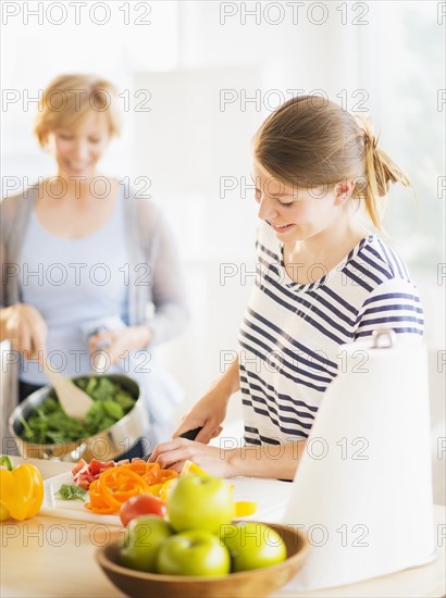 Mother and adult daughter cooking together.
Photo : Daniel Grill