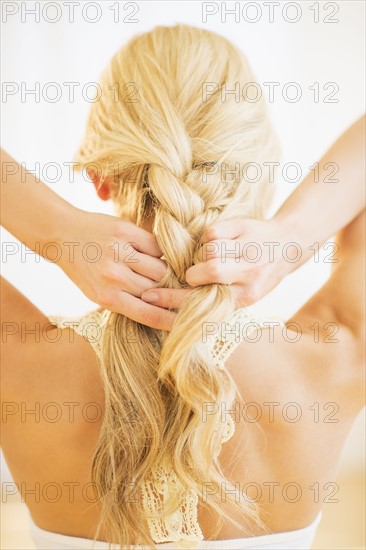 Teenage girl (16-17) braiding hair.
Photo : Daniel Grill