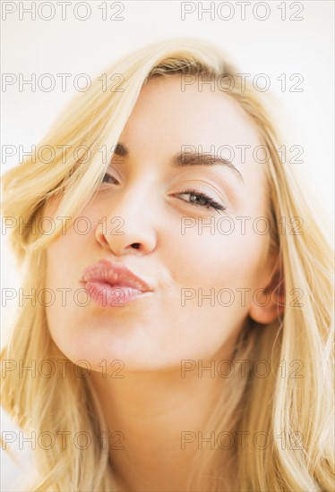 Portrait of teenage girl (16-17) blowing kiss.
Photo : Daniel Grill