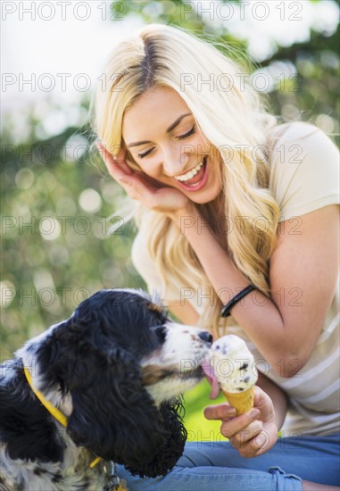 Portrait of teenage girl (16-17) with dog licking ice cream.
Photo : Daniel Grill