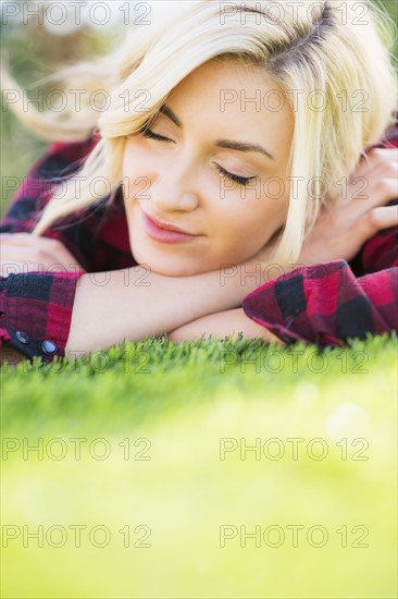 Teenage girl (16-17) sleeping on grass.
Photo : Daniel Grill