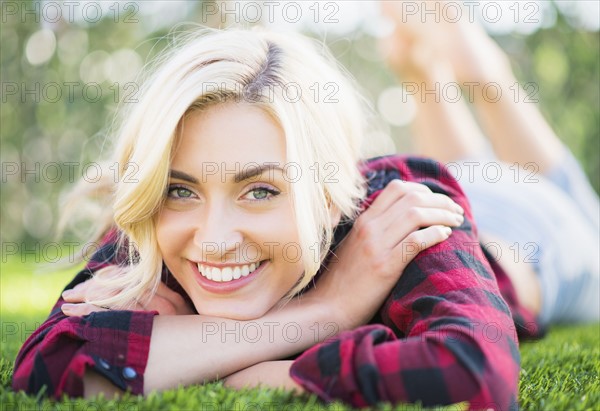 Portrait of teenage girl (16-17) lying on grass.
Photo : Daniel Grill