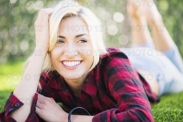 Portrait of teenage girl (16-17) lying on grass.
Photo : Daniel Grill