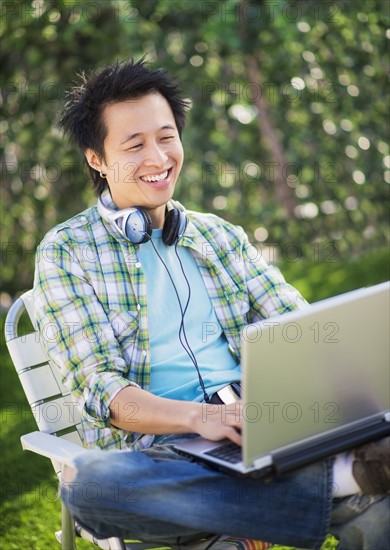 Teenage boy (16-17) using laptop in park.
Photo : Daniel Grill