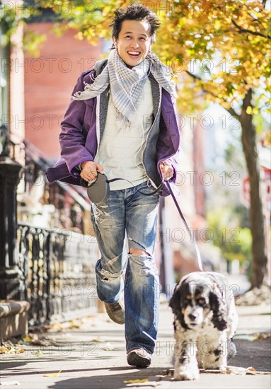 Teenage boy(16-17) walking with dog. USA, New Jersey, Jersey City.
Photo : Daniel Grill