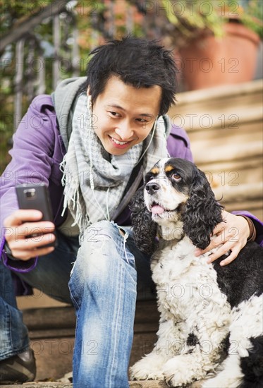 Teenage boy(16-17) taking picture of his dog. USA, New Jersey, Jersey City.
Photo : Daniel Grill