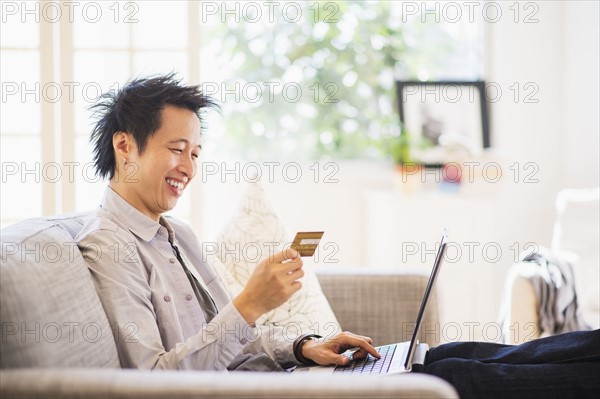 Teenage boy (16-17) shopping on-line.
Photo : Daniel Grill