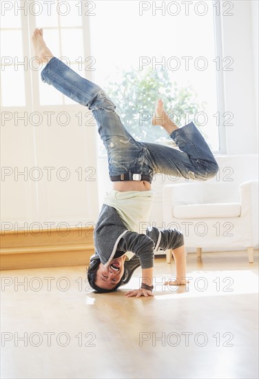 Teenage boy (16-17) dancing in living room.
Photo : Daniel Grill