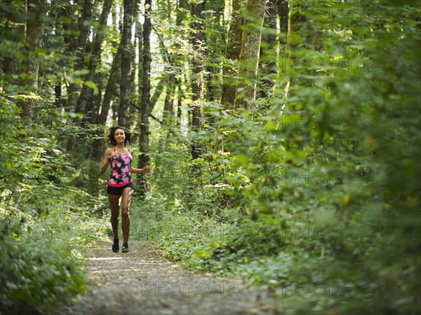 Young women jogging in forest. USA, Oregon, Portland.