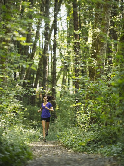 Young women jogging in forest. USA, Oregon, Portland.