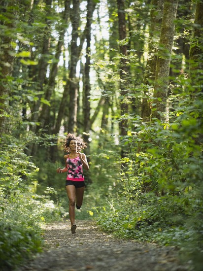 Young women jogging in forest. USA, Oregon, Portland.