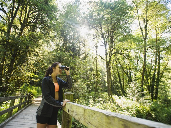 Portrait of woman looking at view with binoculars. USA, Oregon, Portland.